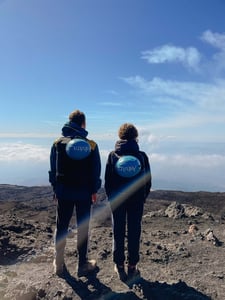 Zwei Menschen von hinten fotografiert. Sie stehen auf Etna